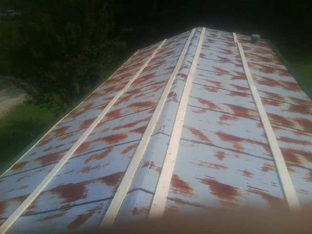 Rusted metal roof panels with new wood purlins before replacement — Storm Damage Roof Repair in Westlake by Roofing Brothers