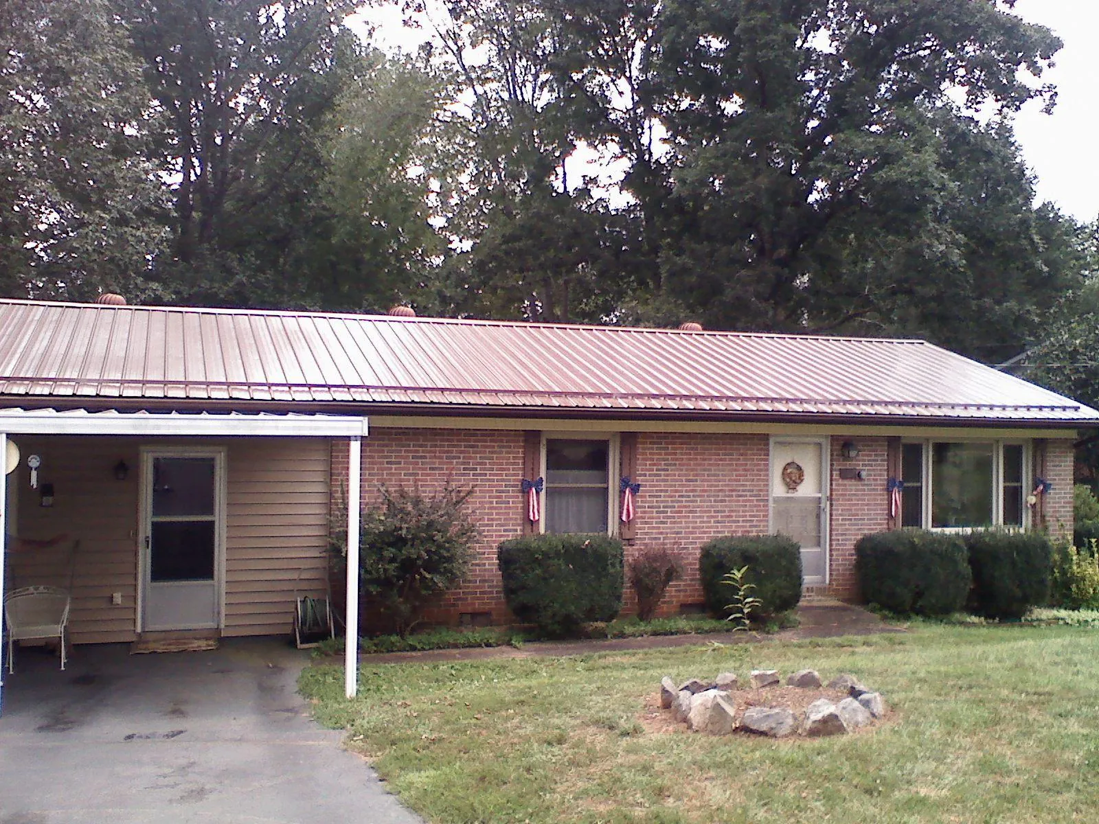 Bronze metal roof and carport on a brick ranch home — Roof Repair work by our crew in Westlake
